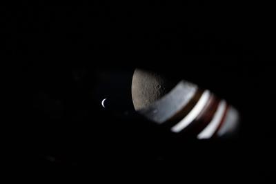 Moon and crescent Earth through a lens